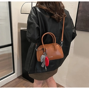 Detalle de bolso Boston de cuero marrón con logo Clear K y cinta de cuadros