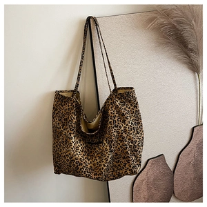 Detail of classic leopard print tote bag with long shoulder straps in a cozy setting