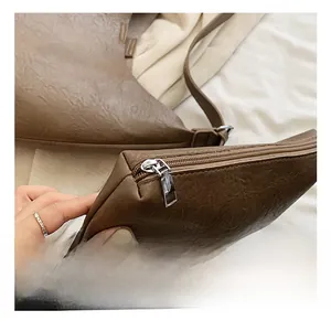 Detail of silver metal zipper on vintage textured brown leather tote bag