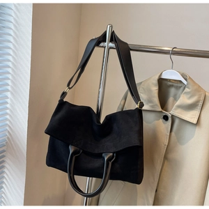 Dettaglio della borsa tote in pelle scamosciata nera con patta e hardware in ottone