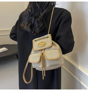 Détail du sac à dos en tweed beige avec fil métallisé et chaînes porté par un mannequin