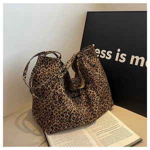 Detail shot of leopard print canvas tote bag with thick straps on a minimalist background