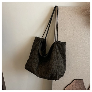 Close-up of a dark green leopard print tote bag made of soft canvas fabric in hobo style