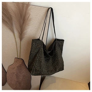 Close-up of leopard print tote bag hanging against a warm minimalist textured wall