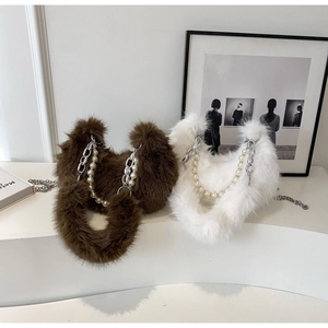 Détail de sacs en peluche en forme de croissant avec perles et chaînes argentées en deux tons
