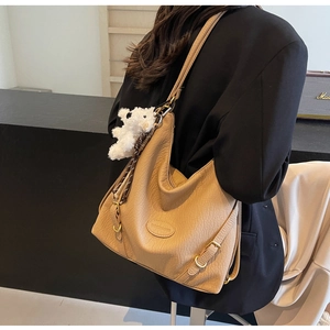 Detail of khaki large crossbody bag with lychee texture leather and plush bear charm