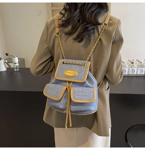 Vue arrière d'un mannequin portant le sac à dos en denim bleu avec détails en cuir