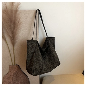 Detail of a large leopard print tote bag hanging on a wall with elegant dried flowers