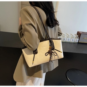 Detail of the chic knot decoration on a large two-tone leather tote bag for women