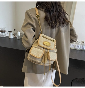 Gros plan du sac à dos beige texturé à cordon avec garniture en cuir et chaîne dorée