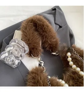 Détail de la poignée en peluche marron avec chaîne de perles et boucle argentée