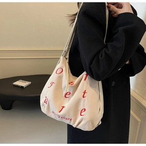 Detail of cream corduroy tote bag with red Future embroidery and leather strap