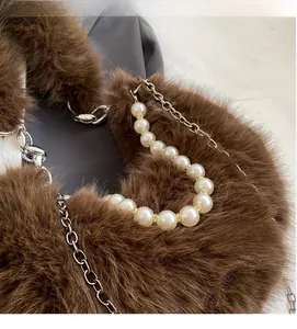 Détail de la fourrure synthétique brune avec anse en perles et chaîne argentée