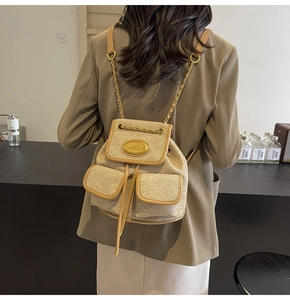 Détail du sac à dos tissé vintage avec finitions en cuir et chaînes dorées sur un mannequin