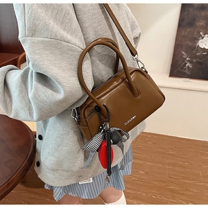 Detalle del bolso Boston en cuero PU marrón con lazo decorativo y logotipo Clear K