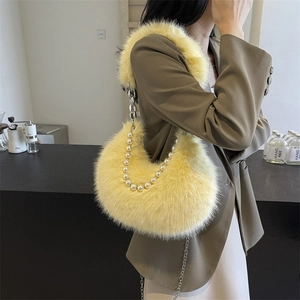 Sac demi-lune en fausse fourrure avec perles et chaîne porté par un mannequin