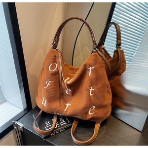 Detail of caramel corduroy tote with 'Our future' embroidery and leather straps