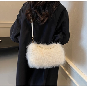 Detailed shot of white faux fur shoulder bag with pearl handle and golden hooks