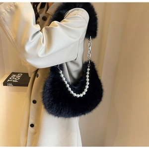 Détail du sac d'épaule en peluche noire avec perles décoratives et chaînes argentées