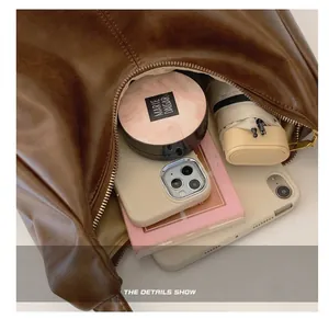 Macro view of spacious dark brown dumpling bag showing interior capacity and smooth PU leather