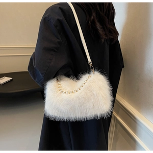 Detail of white faux fur shoulder bag featuring decorative pearl handle chain