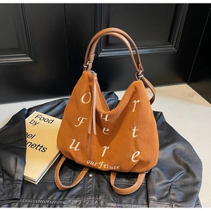 Detail of caramel corduroy tote with Our Future embroidery and leather handles