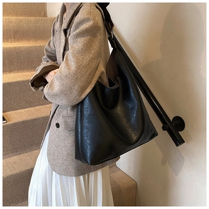 Close-up of black PU leather tote bag with lychee texture for daily autumn fashion