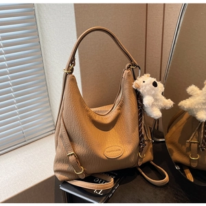 Detail of khaki hobo bag with pebble leather texture and cute white bear pendant charm