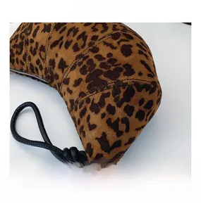 Close-up of leopard print crossbody bag showing textured faux pony hair fabric and details