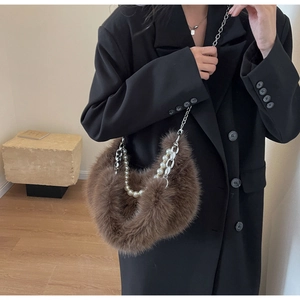Détail d'un sac en peluche marron avec bandoulière élégante en perles et chaîne