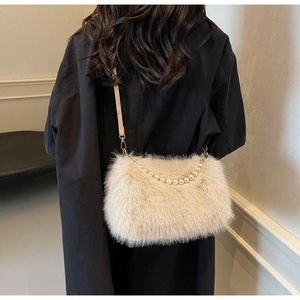 Detail view of cream faux fur shoulder bag with pearl chain and leather strap