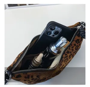 Detailed interior of plush leopard print shoulder bag with zipper pocket and brown lining