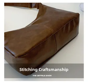 Detail of reinforced double stitching on vintage brown leather tote bag bottom