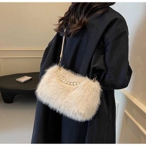 Close-up of beige faux fur shoulder bag with pearl handle and plush texture detail