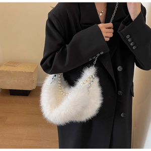 Détail d'un sac sous le bras en fausse fourrure blanche avec chaîne argentée et perles