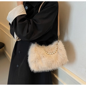 Detail showing plush faux fur texture and elegant pearl handle on beige crossbody bag