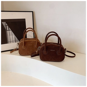 Vue détaillée de deux sacs à main en daim marron clair et foncé avec détails dorés
