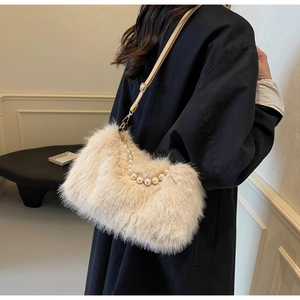 Detail of plush faux fur shoulder bag featuring an elegant large pearl handle and strap
