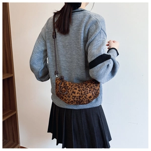 Detail of leopard print croissant bag with adjustable knotted leather shoulder strap