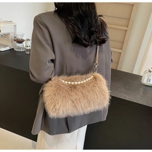 Detail of camel plush shoulder bag featuring elegant oversized pearl chain and soft faux fur
