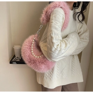 Détail du sac croissant en peluche rose avec chaîne de perles et texture fausse fourrure