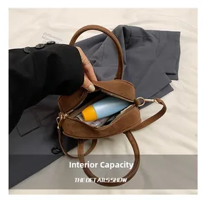 Capacité interne du sac Boston en daim marron foncé montrant l'espace de rangement