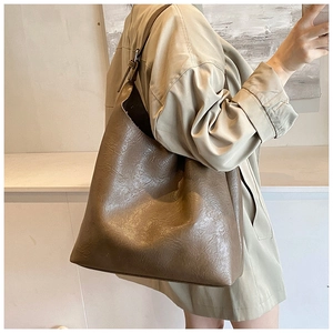 Detail of deep brown PU leather tote bag showing unique wrinkled texture and large capacity