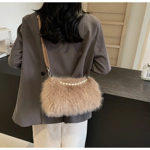 Detail of plush crossbody bag with pearl trim and brown strap on a grey blazer