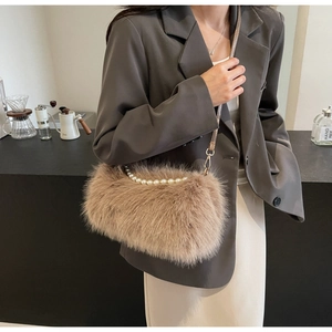 Close-up of khaki plush crossbody bag with white faux pearl handle and gold hardware
