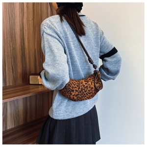 Detailed back view of a trendy leopard print crescent crossbody bag with knotted strap
