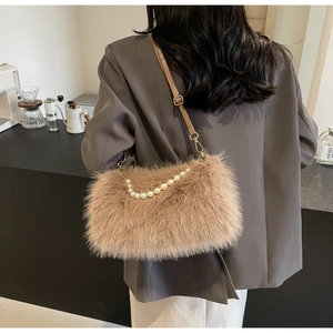 Rear view of a model wearing the brown faux fur bag with pearl handle and leather strap