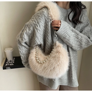 Détail du sac croissant en peluche beige avec perles et bandoulière en chaîne