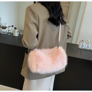 Macro detail of plush light pink handbag featuring pearl handle and soft fur texture
