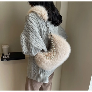 Détail du sac à bandoulière en fausse fourrure beige clair avec chaîne en perles
